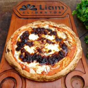 Uma pizza, sobre uma tábua de cortar, com cebolas caramelizadas